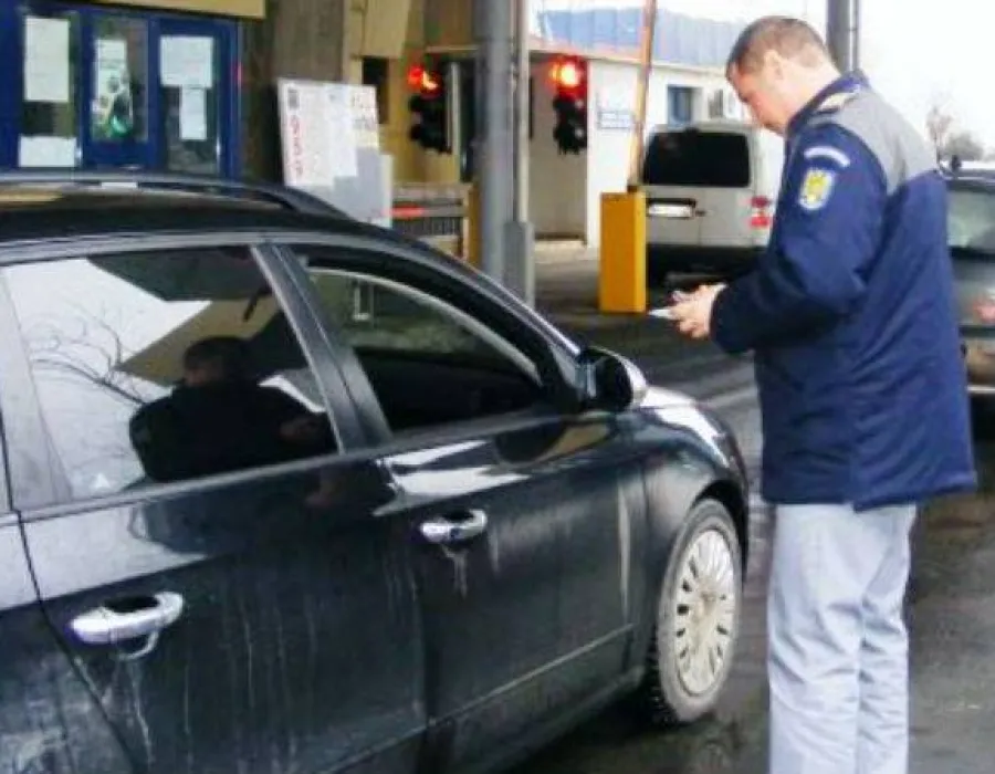 Foto A vrut să iasă din ţară ascuns sub mocheta unei maşini!